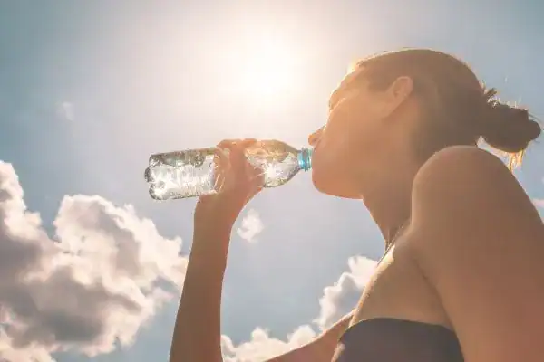 Hydration: The Secret Ingredient for a Toned Stomach and Enhanced Fitness 3 Image of woman drinking water to hydrate Doncaster after run.
