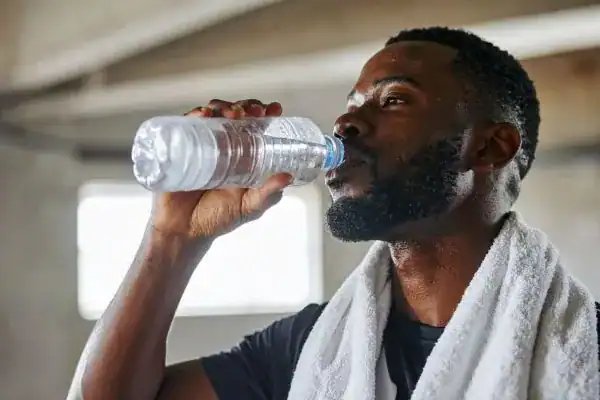Hydration: The Secret Ingredient for a Toned Stomach and Enhanced Fitness 1 Image of man drinking water to improve hydration Doncaster after work out.